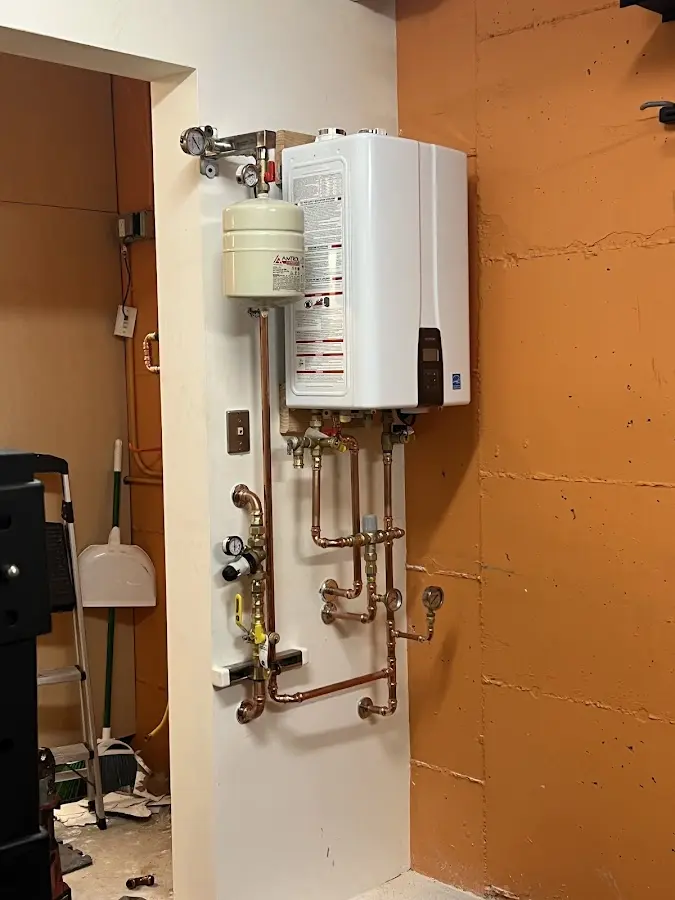 Plumbing technician inspecting water heater connections in Simpsonville